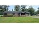 Charming brick home featuring a covered porch and well-maintained lawn at 1206 French Rd, Mullins, SC 29574