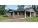 Inviting covered porch with classic brickwork and a cozy swing, perfect for relaxation at 1206 French Rd, Mullins, SC 29574