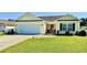 Charming single-story home featuring a manicured lawn, attached garage, and inviting front entrance at 1300 Ruddy Ct., Conway, SC 29527