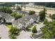Aerial view of condos showing parking spaces, lush trees, landscaping, and nearby highway at 134 Scotch Broom Dr. # K - 201, Little River, SC 29566