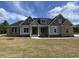 Beautiful new construction home featuring brick and grey siding, a covered porch, and professional landscaping at 140 Pottery Landing Dr., Conway, SC 29527
