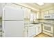 Kitchen features white appliances, cabinets, and a stainless steel sink under a window with bright lighting at 1425 Teague Rd. # 203, Myrtle Beach, SC 29577