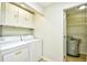 Well lit laundry room with washer, dryer, storage cabinet, and water heater at 1425 Teague Rd. # 203, Myrtle Beach, SC 29577