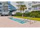 Outdoor hot tub surrounded by a brick surface, lawn, and shrubs at 14290 Ocean Hwy. # 407, Pawleys Island, SC 29585