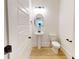 Bright powder room featuring a pedestal sink, toilet, and framed oval mirror at 1464 Hawthorn Dr., Pawleys Island, SC 29585