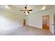 Spacious bedroom featuring carpet, white walls, tray ceiling with fan, and neutral decor at 1464 Hawthorn Dr., Pawleys Island, SC 29585