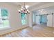 Dining space with wood-look floors, chandelier, and views of adjacent rooms through windows and sliding barn doors at 1464 Hawthorn Dr., Pawleys Island, SC 29585
