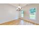 Dining area with wood-look floors, shiplap walls, a modern chandelier, and natural light from two windows at 1464 Hawthorn Dr., Pawleys Island, SC 29585