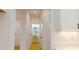 Hallway featuring an oval mirror, pedestal sink in the powder room, and light wood flooring at 1464 Hawthorn Dr., Pawleys Island, SC 29585
