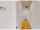Hallway displaying wood-look floors, a thermostat, and bright white walls at 1464 Hawthorn Dr., Pawleys Island, SC 29585