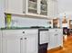 Wet bar area with white cabinets, marble countertops, wine cooler and a view into the dining room at 1510 North Shore Dr, Sunset Beach, NC 28468