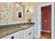 Stylish bathroom with floral wallpaper, granite countertop, and decorative mirror at 1510 North Shore Dr, Sunset Beach, NC 28468