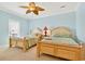 Cozy bedroom with two beds, ceiling fan, and natural light at 1510 North Shore Dr, Sunset Beach, NC 28468