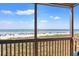 A screened-in balcony with a view of the beach and ocean beyond the grassy dunes at 208 N Ocean Blvd. # 226, North Myrtle Beach, SC 29582