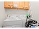 Laundry room with a white washer and dryer, as well as overhead storage cabinets at 208 N Ocean Blvd. # 226, North Myrtle Beach, SC 29582