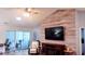 Cozy living room with decorative wood accent wall, mounted TV, ceiling fan, and plenty of natural light at 219 Birdie Way, Longs, SC 29568