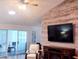Inviting living room with wood-look accent wall, mounted TV, recliner, and sliding glass doors at 219 Birdie Way, Longs, SC 29568