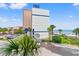 Beautiful coastal building exterior with a blue trim, and palm tree lined parking area at 2311 S Ocean Blvd. # 341, Myrtle Beach, SC 29577