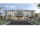 Beautiful exterior view of condos with palm trees and the entrance reads 