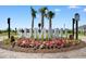 Beautifully landscaped entrance sign with vibrant flowers and mature palm trees at 2438 Polaris Path, Myrtle Beach, SC 29577