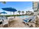Outdoor pool area with lounge chairs, umbrellas, and lush landscaping with ocean view at 2504 N Ocean Blvd. # 1936, Myrtle Beach, SC 29577