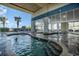 Inviting indoor pool area with clear glass windows, lounge chairs, and palm trees, perfect for relaxing and unwinding year-round at 2504 N Ocean Blvd. # 936, Myrtle Beach, SC 29577
