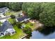 An aerial view showcasing a home with a pond, patio, and lush green landscaping backing up to woods at 2611 Ringneck Trail, Myrtle Beach, SC 29588