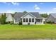 A view of a well maintained backyard with a grilling and outdoor seating area on a sunny day at 2783 Sanctuary Blvd., Conway, SC 29526