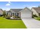 Charming single-story home with manicured lawn, lush landscaping, and a two-car garage at 2783 Sanctuary Blvd., Conway, SC 29526