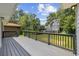 Back deck view with gray paint, wooden railings, and a green backyard surrounded by mature trees at 3537 Lighthouse Way, Myrtle Beach, SC 29577