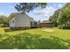 Grassy backyard with deck, brick foundation and sand area for activities at 3537 Lighthouse Way, Myrtle Beach, SC 29577