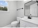 Bathroom featuring a white vanity, toilet, mirror, and a window bringing in natural light at 3537 Lighthouse Way, Myrtle Beach, SC 29577