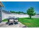 A view of a large, green backyard with a white fence, table and chairs, and a tree under a clear blue sky at 365 Lenox Dr., Conway, SC 29526
