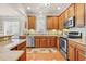 Well-lit kitchen features light wood cabinets, stainless steel appliances, granite counters, and stylish backsplash at 431 Huntington Lake Circle # 80, Pawleys Island, SC 29585