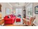 Comfortable living room with a red sofa, patterned armchairs, bright pillows, and hardwood floors under a ceiling fan at 431 Huntington Lake Circle # 80, Pawleys Island, SC 29585