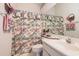 Cozy bathroom with floral patterned shower curtain and vanity with a sink at 4703 Bermuda Way, Myrtle Beach, SC 29577