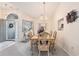 Dining area bathed in natural light, showcasing an elegant chandelier and backyard views at 4703 Bermuda Way, Myrtle Beach, SC 29577