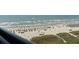 Bustling beach view with people enjoying umbrellas, and boats sailing in the distance at 4800 S Ocean Blvd. # 1008, North Myrtle Beach, SC 29582