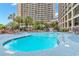 Large outdoor pool with ample seating and palm trees, ideal for a refreshing swim at 4800 S Ocean Blvd. # 1008, North Myrtle Beach, SC 29582