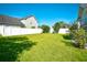 Spacious backyard featuring lush green grass, a white fence, and mature landscaping at 501 Painted Duck Ct., Myrtle Beach, SC 29588