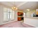 Open dining room featuring chandelier lighting, large window, and a view into the kitchen at 501 Painted Duck Ct., Myrtle Beach, SC 29588