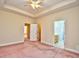 Large primary bedroom featuring a ceiling fan, neutral walls, and ensuite access to the bathroom at 501 Painted Duck Ct., Myrtle Beach, SC 29588