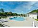 Community pool surrounded by lounge chairs offers a relaxing retreat with trees in the background at 501 Painted Duck Ct., Myrtle Beach, SC 29588