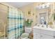 Cozy bathroom features a shower with blue striped curtain and a vanity with white cabinets and matching counter-top at 509 June Bug Ct., Myrtle Beach, SC 29588