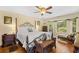 Serene bedroom with four poster bed, hardwood floors, and cozy seating area near a bright window at 509 June Bug Ct., Myrtle Beach, SC 29588