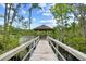 Picturesque gazebo at the end of a wooden bridge over a tranquil lake, creating a serene retreat at 509 June Bug Ct., Myrtle Beach, SC 29588