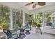Relaxing screened porch with wicker furniture and potted plants offers a serene view of the lush backyard at 509 June Bug Ct., Myrtle Beach, SC 29588