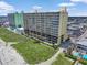 A high-rise complex is set on lush green lawns next to a sandy beach with the ocean beyond at 5404 N Ocean Blvd. # 11-D, North Myrtle Beach, SC 29582