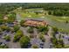 An aerial view captures a clubhouse with a large parking lot, well manicured grounds, and a scenic lake at 5801 Oyster Catcher Dr. # 832, North Myrtle Beach, SC 29582