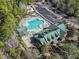Aerial view showcasing the community pool, clubhouse, and ample parking surrounded by lush greenery at 5904 Bridlewood Rd., North Myrtle Beach, SC 29582
